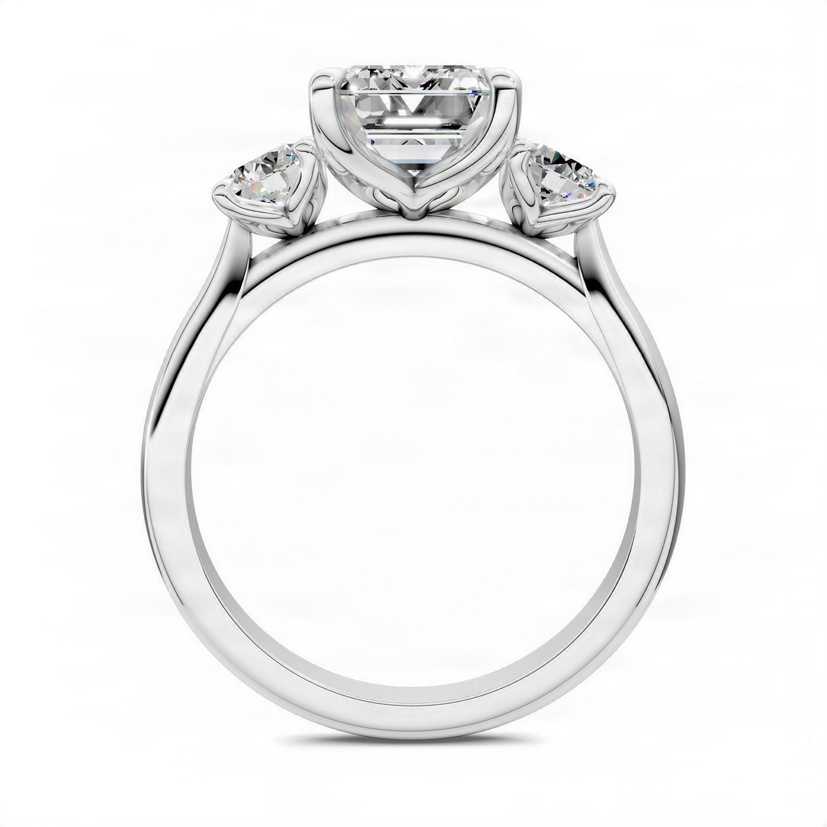 Three-stone ring top view with emerald-cut center and round side stones, platinum-tone