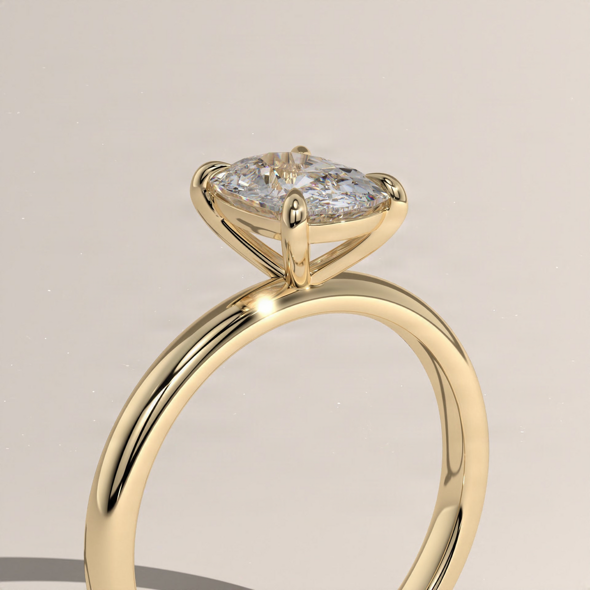 Yellow gold solitaire ring with cushion diamond and tapered band, close-up